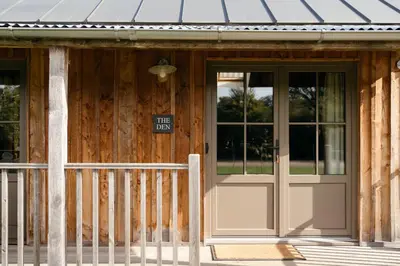 a wooden building with a door and a sign on it at Retreat East in Ipswich