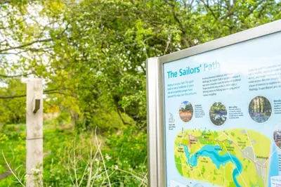 a sign in a park with trees in the background at Marsh View in Aldeburgh