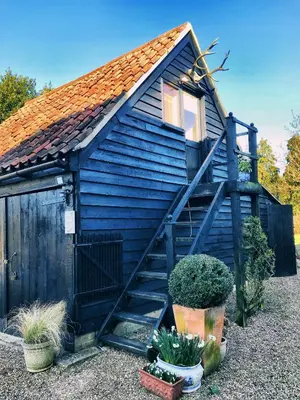a blue house with a staircase in a yard at The Apple Loft in Westleton