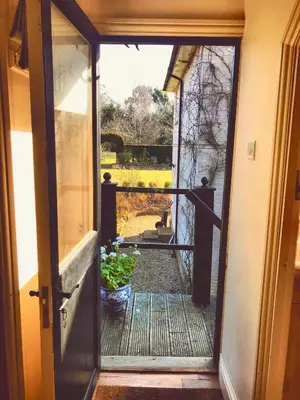 an open door to a porch with a potted plant at The Apple Loft in Westleton