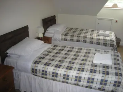 two beds in a hotel room with a plaid blanket at Richmond Park Golf Club in Watton