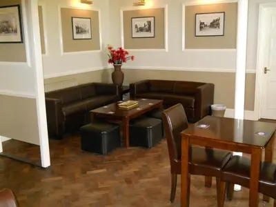a living room with a couch and a table and chairs at Richmond Park Golf Club in Watton