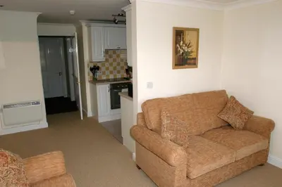 a living room with a couch and a kitchen at Richmond Park Golf Club in Watton