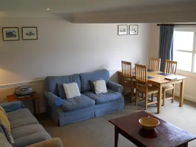 a living room with a blue couch and a table at Richmond Park Golf Club in Watton