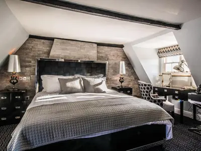 a bedroom with a large bed and a brick wall at The Royal Standard in Ely