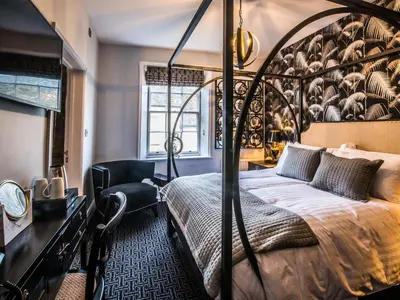 a bedroom with a large bed and a chair at The Royal Standard in Ely