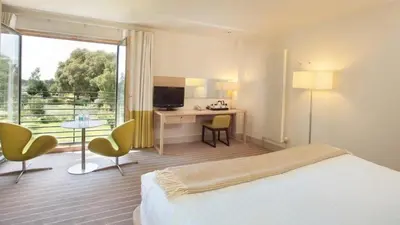 a hotel room with a bed and a desk and a television at Lifehouse Spa And Hotel in Frinton-on-Sea