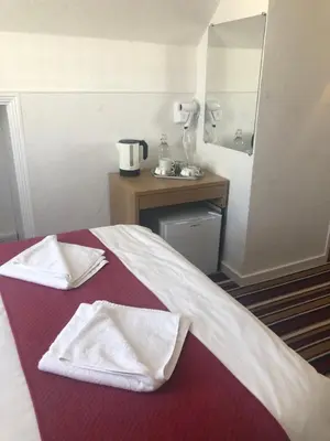 a hotel room with a bed with towels on it at The Grosvenor in Clacton-on-Sea