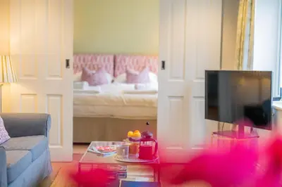 a living room with a couch and a tv at Marsh Lodge in Aldeburgh
