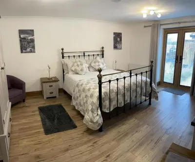 a bedroom with a bed and a wooden floor at Grove Barn Bed and Breakfast in Harleston