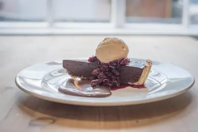 a piece of chocolate cake with ice cream on a plate at The Golden Key in Snape