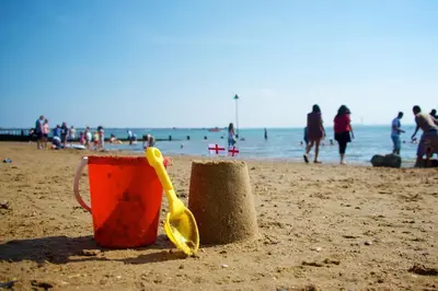 an orange cup and two sand castles on a beach at Southend Central Hotel - Close to Beach, City Centre, Train Station & Southend Airport in Southend-on-Sea