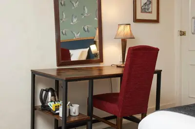 a desk with a red chair and a mirror at Bull Hotel by Greene King Inns in Long Melford