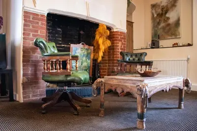 a living room with a chair and a table at The Scole Hotel in Scole