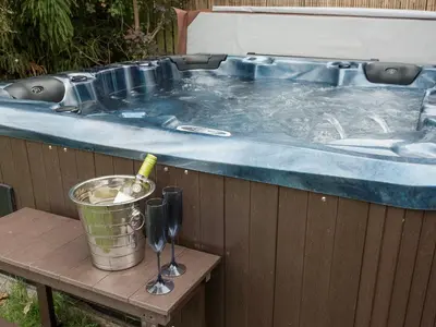 a jacuzzi tub with a bucket on a table at Horseshoe House - Ukc2743 in Watton