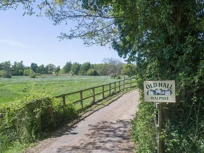 a sign on a dirt road next to a fence at Henry's Barn - Ukc3168 in Walpole
