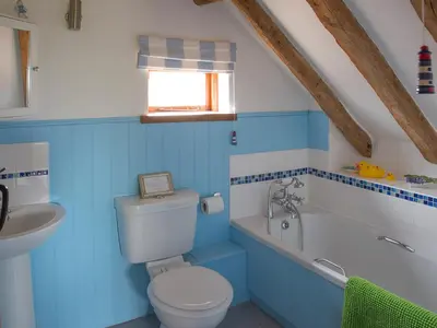 a blue bathroom with a toilet and a sink at Henry's Barn - Ukc3168 in Walpole