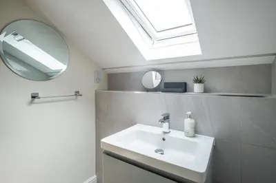a bathroom with a sink and a mirror at Avocet Cottage in Aldeburgh