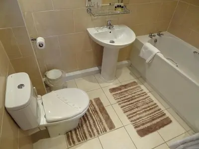 a bathroom with a toilet and a sink and a tub at The Chudleigh in Clacton-on-Sea