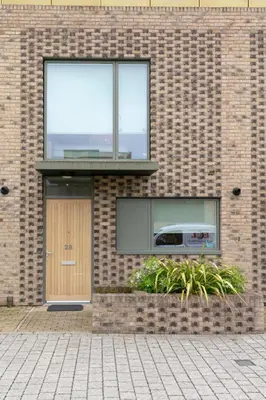 a brick building with a window and a door at Modern & Exquisite Trumpington Townhouse with Parking & 5 mins to Papworth hospital in Cambridge