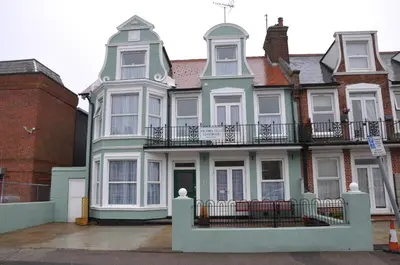 a large house with a balcony on a street at Victoria Villa Guesthouse in Clacton-on-Sea