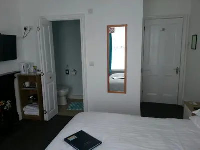a bedroom with a bed and a mirror and a bathroom at Victoria Villa Guesthouse in Clacton-on-Sea