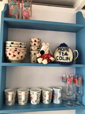 a teddy bear sitting on a shelf with cups at Endymion Lodge in Colchester
