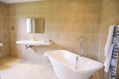 a bathroom with a tub and a sink at Ransom Lodge in Chappel