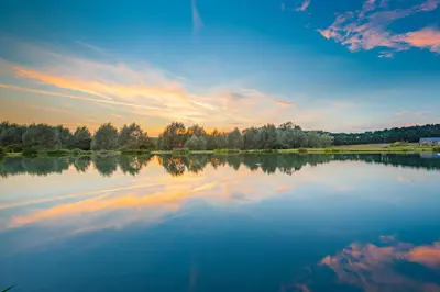 a large body of water with a sunset in the background at Brook Lodge in Colchester