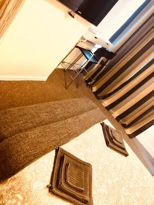 a living room with a rug and a bed at AC Lounge 125 in Rochford