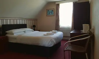 a bedroom with a bed with towels on it at The Langtry Hotel in Clacton-on-Sea