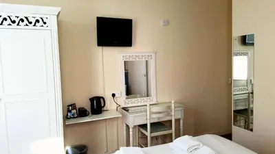 a bedroom with a bed and a mirror and a desk at The Langtry Hotel in Clacton-on-Sea