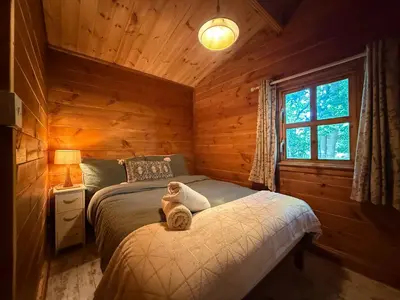 a bedroom with a bed with a teddy bear on it at West Stow Pods in Bury St Edmunds in West Stow