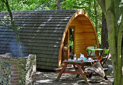 a small cabin with a table in front of it at West Stow Pods in Bury St Edmunds in West Stow
