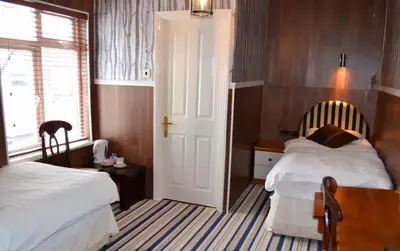 a hotel room with two beds and a window at Ely Guest House in Ely