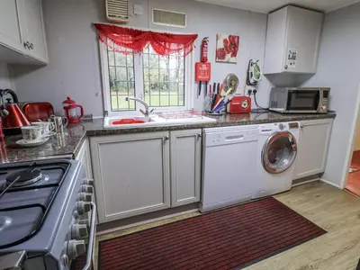 a kitchen with a washing machine and a sink at The Lodge in Attleborough