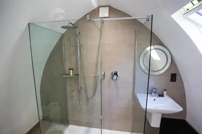 a bathroom with a shower and a sink at Tuddenham Mill Luxury Hotel in Tuddenham