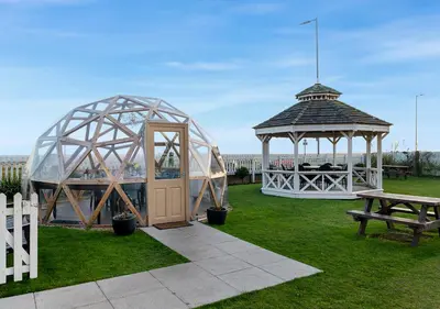a gazebo and a pavilion with a picnic table and a bench at Kingscliff, Holland on Sea in Clacton-on-Sea