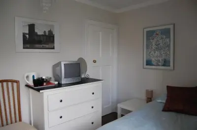 a bedroom with a bed and a tv on a dresser at The Castle Bar ROOM ONLY in Cambridge