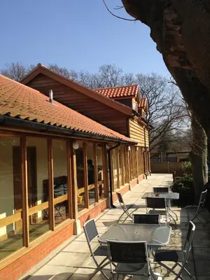a patio with tables and chairs in front of a building at The Olde Windmill Inn in Great Cressingham