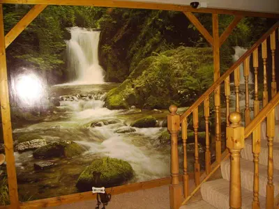 a staircase with a painting of a waterfall at Stansted Airport Lodge in Takeley