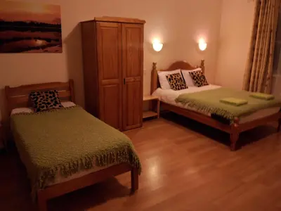 a bedroom with two beds and a dresser at Stansted Airport Lodge in Takeley
