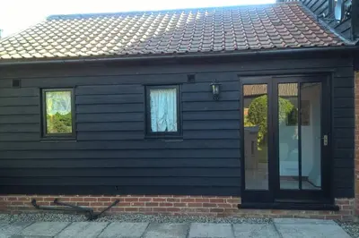 a house with a door and two windows at South Barn in Stanningfield