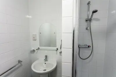 a white bathroom with a sink and a mirror at Roydon Marina Village Hotel in Roydon