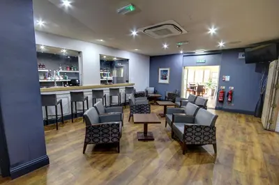 a salon with chairs and a bar with a counter at The Rochford Hotel in Southend-on-Sea