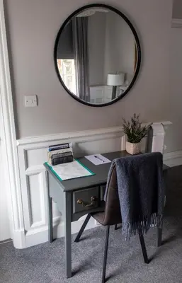 a desk with a mirror and a chair in a room at J.D.Young in Harleston