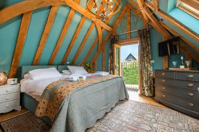 a bedroom with a bed in a room with a window at Corner Farm in Halesworth