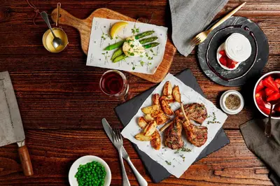 a wooden table with plates of food on it at Hanbury Manor Marriott Hotel & Country Club in Ware