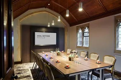 a conference room with a long table and chairs at Hanbury Manor Marriott Hotel & Country Club in Ware