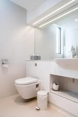 a white bathroom with a toilet and a sink at Hinxton Hall Hotel and Conference Centre in Hinxton